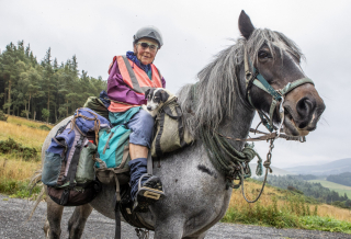 Illustration de l'article : À l'âge de 80 ans, cette femme  grimpe sur son cheval pour un périple de 7 semaines tous les ans, en compagnie de son chien handicapé 