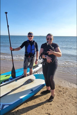 Illustration de l'article : Piégée par la marée montante sur un banc de sable, une petite femelle Bouledogue Français reçoit l’aide providentielle de 2 paddleboarders